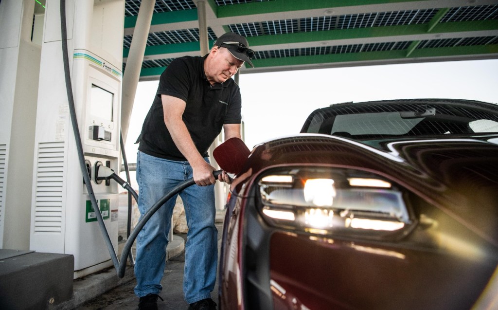 Wayne Geddes filling a Porsche Taycan en route to an electric car distance record