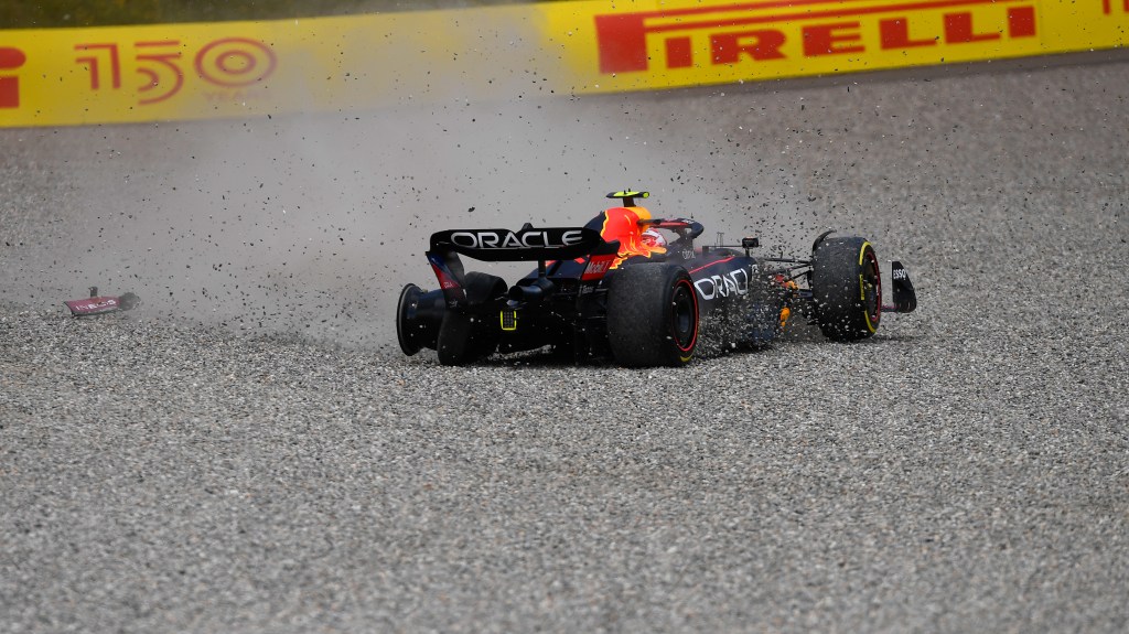 SPIELBERG, AUSTRIA - JULY 10: Sergio Perez of Mexico driving the (11) Oracle Red Bull Racing RB18 runs through the gravel after a collision with George Russell of Great Britain and Mercedes during the F1 Grand Prix of Austria at Red Bull Ring on July 10, 2022 in Spielberg, Austria. (Photo by Rudy Carezzevoli - Formula 1/Formula 1 via Getty Images)